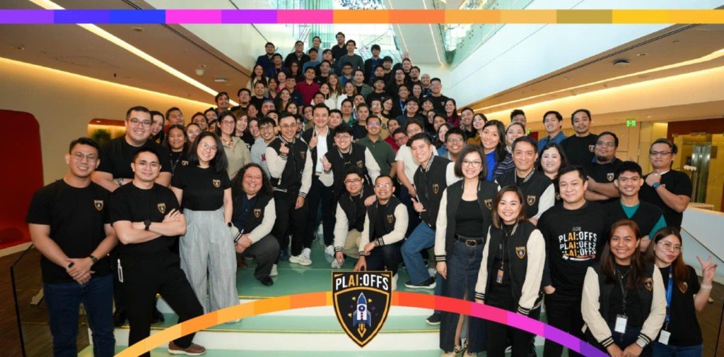 Wide group photograph of colleagues gathered on a modern office staircase during a professional development event